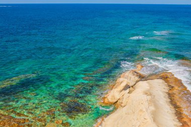 Malta 'nın turkuaz suları kayalık ve güneşli kıyı şeridiyle buluşuyor. Sığ su rengarenk sualtı manzarasını ortaya çıkarır. Turkuazdan derin okyanus kayalarına geçişi vurgulayan hava manzarası