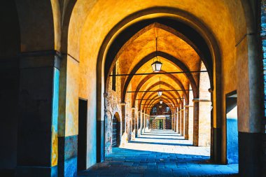 Yüksek kemerli uzun koridor taştan zeminde ışık ve gölgenin oynadığı bir kaybolma noktası yaratır. Uzağa uzanan taş kemerlerin tekrarlanan mimari ritmi