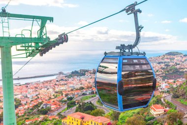 Madeira Cable Car, Funchal şehrinin panoramik görüntülerini sunar. Deniz kenarı kasabasının kentsel yayılımını yakalayan gelişmiş perspektif. Arka planda Atlantik Okyanusu görünüyor.