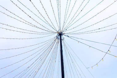 Işıklar simetrik olarak merkezi bir kutuptan yayılarak soluk gökyüzüne karşı neşeli bir gölgelik oluştururlar. Geometrik desen dengeli görsel ritimle çarpıcı bir yıldız patlaması etkisi yaratır