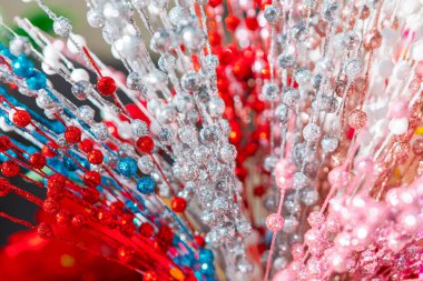 Yumuşak arka planda parlak bayram renklerinde boncuklu çelenkler. Parlak boncuklar Noel havasını çağrıştırıyor. Boncuklu aksanlar içeren çeşitli simli çiçek telleri.