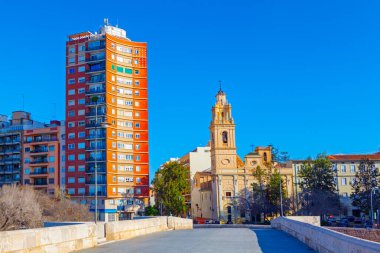 Pont, İspanya, Valencia 'daki Serrans Köprüsü, modern apartman bloğu mimarisi ve tarihi Parroquia del Salvador y Santa Monica kilisesi. Manzara, canlı İspanyol şehrinde güneşli bir günü yakalıyor.