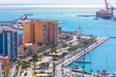 Panoramik manzara, La Farola deniz fenerinin bulunduğu İspanya 'nın Malaga limanını gösteriyor. Titrek gezinti alanı Endülüs 'teki gök mavisi Akdeniz kıyısında boş zaman aktiviteleri sunuyor