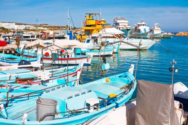 Kıbrıs 'taki Ayia Napa Limanı, renkli geleneksel balıkçı tekneleriyle dolu. Sakin turkuaz sular ve berrak mavi gökyüzü güzel ve huzurlu bir Akdeniz manzarası yaratır.