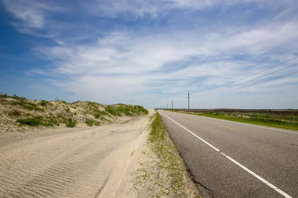 Dunas de areia ao longo da estrada Imagem De Stock