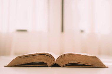 Kütüphanedeki kapalı masa üzerinde açık bir kitap.