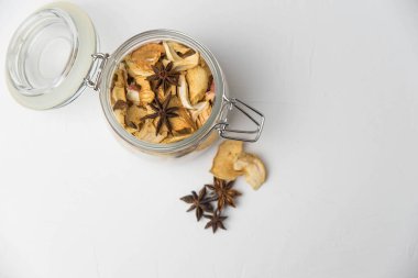 Ev yapımı kavrulmuş, kurutulmuş organik elma dilimleri. Cam kavanozda baharat olan elma cipslerini beyaz arkaplanda izole edilmiş ve metin için kopyalama alanı olan kapat