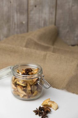 Ev yapımı kavrulmuş, kurutulmuş organik elma dilimleri. Cam kavanozda baharat olan elma cipslerini beyaz arkaplanda izole edilmiş ve metin için kopyalama alanı olan kapat