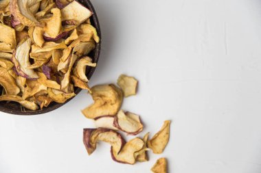 Ev yapımı kavrulmuş, kurutulmuş organik elma dilimleri. Beyaz zemin üzerinde izole edilmiş baharatlı elma cipslerini metin için kopyalama alanı ile kapat