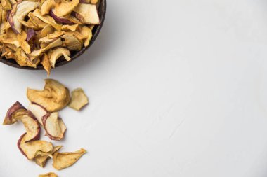 Ev yapımı kavrulmuş, kurutulmuş organik elma dilimleri. Beyaz zemin üzerinde izole edilmiş baharatlı elma cipslerini metin için kopyalama alanı ile kapat