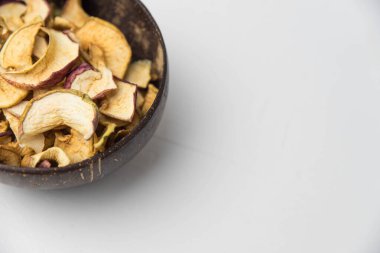 Ev yapımı kavrulmuş, kurutulmuş organik elma dilimleri. Beyaz zemin üzerinde izole edilmiş baharatlı elma cipslerini metin için kopyalama alanı ile kapat