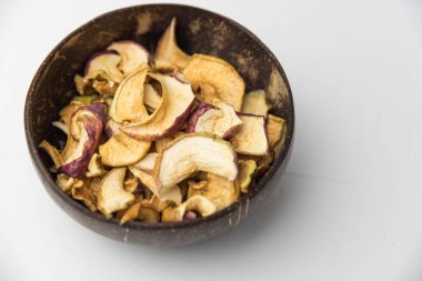 Ev yapımı kavrulmuş, kurutulmuş organik elma dilimleri. Beyaz zemin üzerinde izole edilmiş baharatlı elma cipslerini metin için kopyalama alanı ile kapat