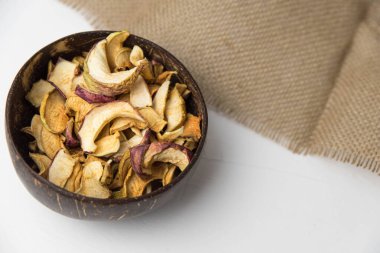 Ev yapımı kavrulmuş, kurutulmuş organik elma dilimleri. Beyaz zemin üzerinde izole edilmiş baharatlı elma cipslerini metin için kopyalama alanı ile kapat