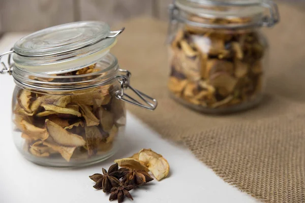 Ev yapımı kavrulmuş, kurutulmuş organik elma dilimleri. Cam kavanozda baharat olan elma cipslerini beyaz arkaplanda izole edilmiş ve metin için kopyalama alanı olan kapat