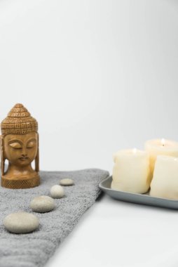 Gri Zen çakıl taşları ve güzellik salonundaki masaj masasında havlu. Sıcak taş masaj seti. Uyum, denge ve meditasyon kavramı, spa, rahatlama, spa tedavisi