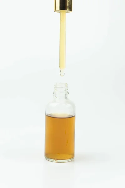 Eteerinen Öljy Tippuu Pipetistä Valkoisella Eristettyyn Pulloon Lähikuva Luonnollinen Orgaaninen — kuvapankkivalokuva