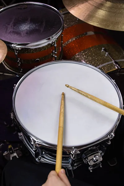 Professional drum set closeup. Man drummer with drumsticks playing drums and cymbals, on the live music rock concert or in recording studio