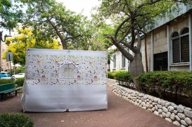 İsrail 'de Yahudi festivali Sukkot. Sokaktaki binanın yanında el yapımı süslemeleri olan geleneksel sukkah.. 