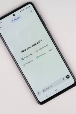 ChatGPT uygulama arayüzünü gösteren masadaki akıllı telefon yapay zeka ve modern teknolojiyi sembolize ediyor..