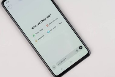 ChatGPT uygulama arayüzünü gösteren masadaki akıllı telefon yapay zeka ve modern teknolojiyi sembolize ediyor..