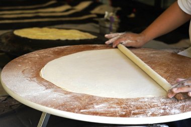Türk kadın hamuru yuvarlıyor Türk gözlüğü. Gözleme, çeşitli lezzetli dolgularla (peynir, patato, ıspanak vs.) doldurulmuş düz ekmeğin yer aldığı geleneksel bir Türk yemeğidir. - Evet. Demir levhada pişmiş.                 