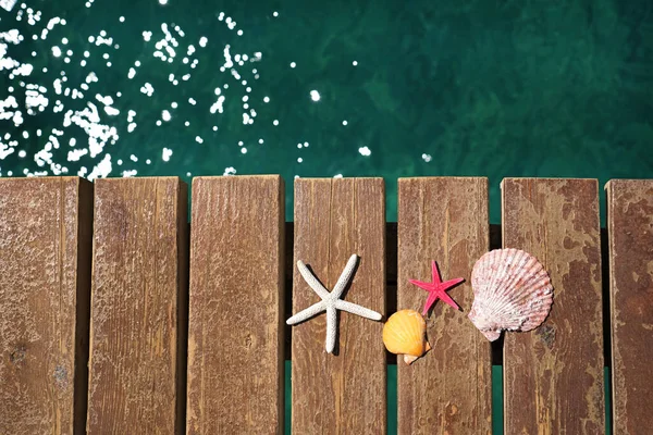 木製のビーチ桟橋上のヒトデや貝殻 夏休みのコンセプト — ストック写真