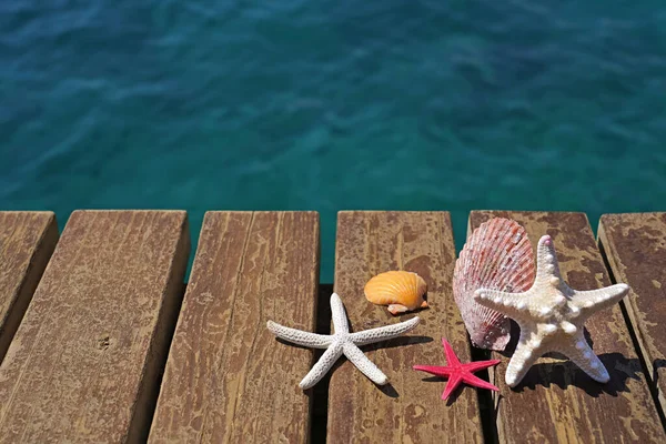 海星和贝壳在木制海滨码头上 暑假的概念 — 图库照片