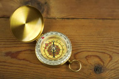 Ahşap arka planda antika bir pusula. Resmi kapat.