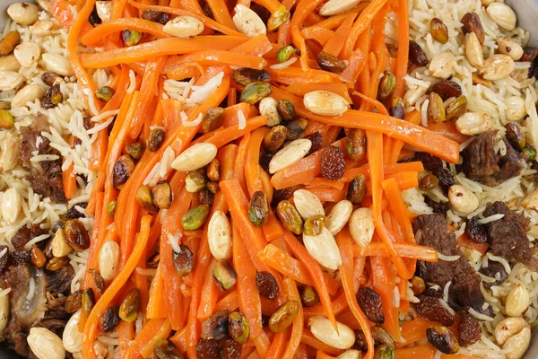Delicious, colorful Afghan rice pilaf ( Kabuli Pilaf) with lamb or chicken meat and raisin, carrot, pistachio, almond, spices.