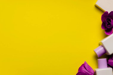 Beyaz iki şişe şampuan, duş jeli, sarı arkaplanda beyaz bir sabun. Leylak sabun çiçekleri. Deri ve saç bakımı. Hijyen ve kozmetik. Güzellik düzlüğü. Yukarıdan bak. Görüntü