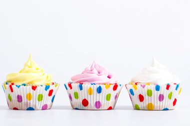 Three festive cupcake on a white background, white, yellow, pink clipart