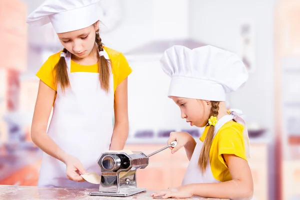 I bambini fanno l'impasto in cucina, arrotolano un mattarello — Foto Stock