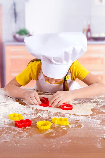Маленькие повара готовят печенье, режут фигурки из теста — стоковое фото
