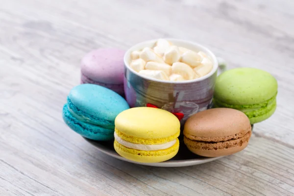 Colección de coloridos macarrones franceses están uno al lado del otro alrededor de los platos — Foto de Stock