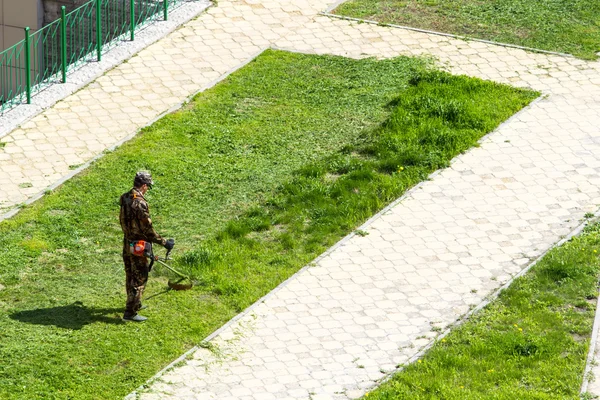 Άνθρωπος κόβει η μηχανή ξακρίσματος χόρτων — Φωτογραφία Αρχείου