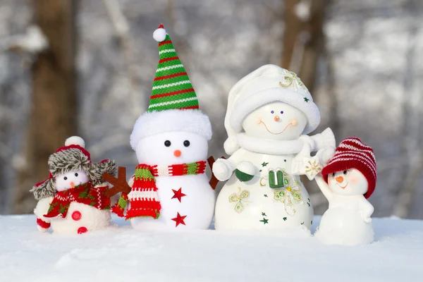 Four snowmen on a snow stand in one row — Stock Photo, Image