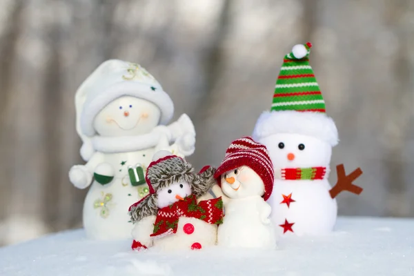 Cuatro muñecos de nieve están de pie uno junto al otro . — Foto de Stock