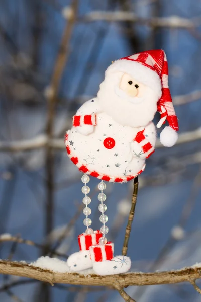 Un muñeco de nieve divertido, Santa Claus colgando de una rama — Foto de Stock