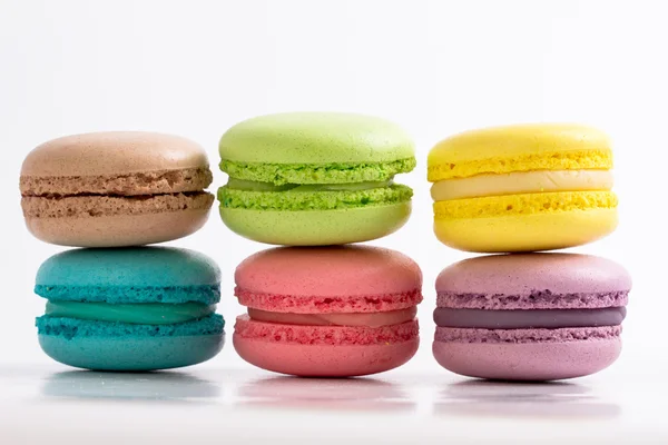 Sześć kolorowych francuskie macarons na białym tle, leżącego na wierzchu — Zdjęcie stockowe