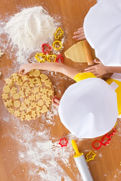 Дитячі кухарі готують печиво, вид зверху — стокове фото