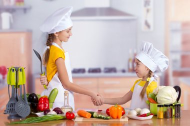 İki neşeli küçük aşçılar el sallamak