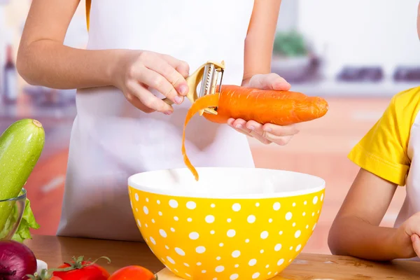 Fille cuisinier grattoir de carotte — Photo
