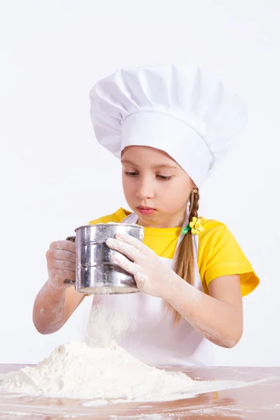 Menina chef segurando uma peneira de farinha — Fotografia de Stock