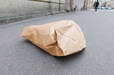 Kaldırıma atılmış buruşmuş fast food poşeti.