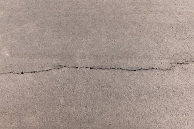 Arkaplan resmi: bir şehir yolunun asfalt yüzeyinde çatlak