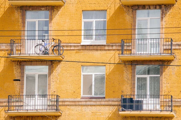 Fasad Ett Gult Tegelhus Med Balkonger Plastfönster Och Cykel Balkongen — Stockfoto