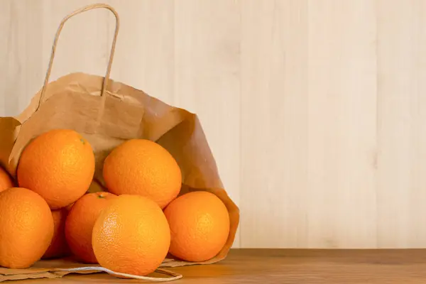 Reife Orangen Einer Papiertüte Auf Einem Holztisch — Stockfoto