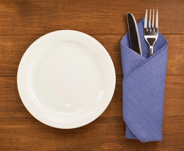 Knife and fork with napkin on wood — Stock Photo, Image