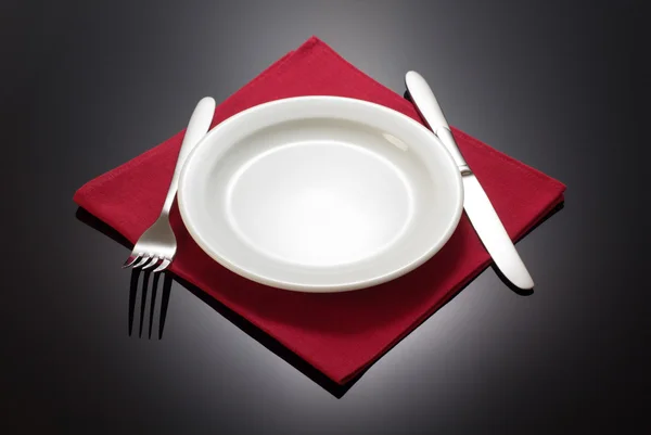 Plattan och gaffel med kniv på servett — Stockfoto