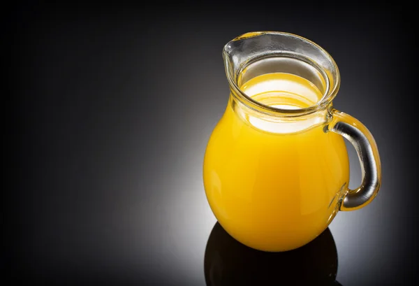 Jarro de vidro e suco de laranja em preto — Fotografia de Stock